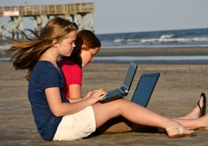 Teens-Work-on-Laptops-at-the-Beach